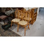 A set of four beech wheelback dining chairs