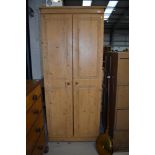 A modern pine wardrobe having carved double doors W73cm x H180cm x D51cm