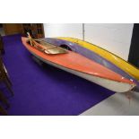 A vintage two person canoe and selection of oars and paddle