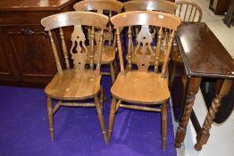 A set of four traditional solid seat kitchen chairs