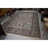 A large wool woven rug or carpet square in cream and blue green grounds in a Kashan design 344cm x