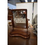 A toilet mirror having tilting mahogany frame