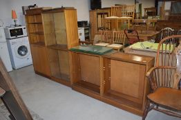 A set of three mid century display library or book shelf cabinets with glass fronts and teak