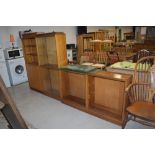 A set of three mid century display library or book shelf cabinets with glass fronts and teak