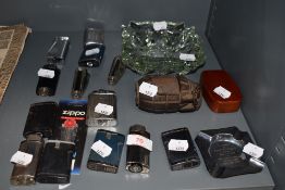 A selection of cigarette and tobacco smokers lighters and trays including hollow hand grenade and