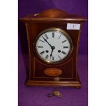An Edwardian inlaid mahogany mantel clock having enamel dial with roman numerals and standard