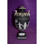 A Jasper ware Black and white basalt lidded urn and cover depicting dancing maids by Wedgwood fine