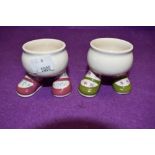 A pair of Carelton ware walking leg Egg cups in green and pink colour ways