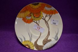 An art deco tea saucer or plate by Clarice Cliff hand decorated with orange daisy stamped Bizarre