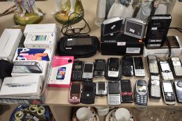 A selection of mobile phones and similar portable electronics including Sony Walkman and Tom Toms