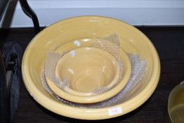 A set of three graduated terracotta salt glazed cream or butter bowls in a traditional farm house