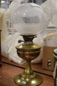 A vintage oil burning lamp having etched glass shade with damage