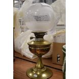 A vintage oil burning lamp having etched glass shade with damage