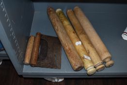 A selection of wooden farm house hand turned rolling pins and two herb chopping knives