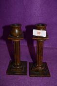 A pair of phenolic bakelite style candle sticks having column and tulip head stems 16cm high approx