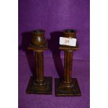 A pair of phenolic bakelite style candle sticks having column and tulip head stems 16cm high approx