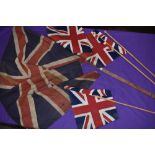 Two hand held British flags and similar larger Union Jack flag possibly military related