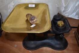 A set of cast kitchen balance scales having brass measure pan and accompanying weights