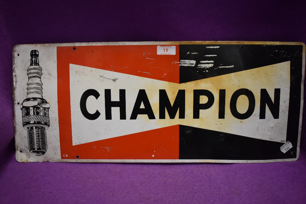 A tin printed garage sign for Champion spark plugs