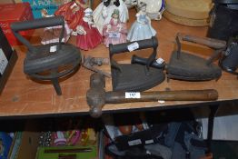 A selection of cast iron items includint two flat stove irons and hammer