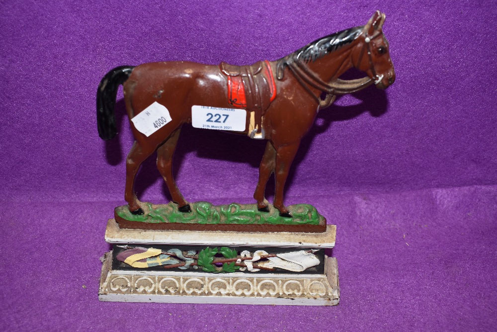 An antique cast iron door stop in the form of a race or riding horse RD 281239 having break to