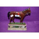An antique cast iron door stop in the form of a race or riding horse RD 281239 having break to