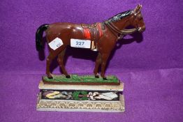 An antique cast iron door stop in the form of a race or riding horse RD 281239 having break to