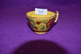 An antique tea cup of small size having hand decoration with mustard yellow glaze and London style