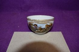 A hard paste porcelain teacup hand decorated with sheep and shepherd bearing the Meissen crossed