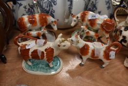 Two calf and cow figures in a Stafforshire style also two creamers