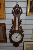 An enamel dial and oak cased barometer having well carve ivy frame