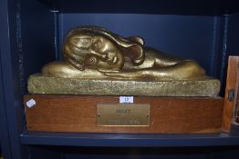 An early 20th century cast sculpture of a resting girl titled Mary on oak plinth by Peggie A E