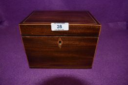 An antique tea caddy having mahogany case with inlayed detailing and foiled compartments