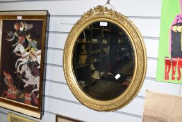 An ornate gilt and gesso framed oval mirror