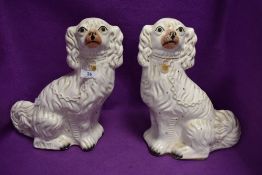 A pair of antique Staffordshire flat back mantle spaniel dogs 33cm tall