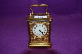 An early 20th century mantle of carriage clock having ornate ormolu and enamel worked face having