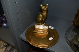 A selection of brass wares including heavy set plate cat figure and desk top revolving calendar with