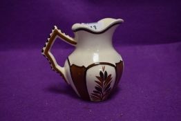 A French water jug in brown and cream grounds signed Quimper 222 HB PC