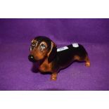A ceramic figure study of a sausage dog by Royal Doulton in fine condition