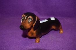 A ceramic figure study of a sausage dog by Royal Doulton in fine condition