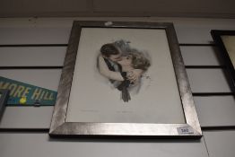 A framed art deco print titled first kiss
