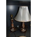 A pair of ceramic table lamps with shades having fruit design and gilt detailing.
