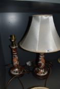 A pair of ceramic table lamps with shades having fruit design and gilt detailing.