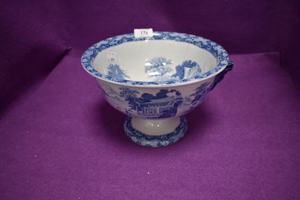 An antique footed bowl having blue and white wear design twin ram head handles and tin glaze has