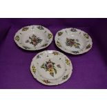 Two bowls and a plate decorated in English Delft styles with heavy glaze and floral scenes all