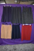 Six vintage skirts mainly 1950s to 1960s, pleated and classic styles, mixed fabrics and sizes.