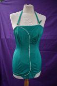 A collectable Janet Dickinson model emerald green 1950s halter neck swim suit with white piping,