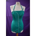 A collectable Janet Dickinson model emerald green 1950s halter neck swim suit with white piping,