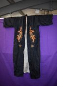 A mid 1940s silk kimono of black silk having embroidered dragons and lined in grey.