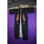 A mid 1940s silk kimono of black silk having embroidered dragons and lined in grey.